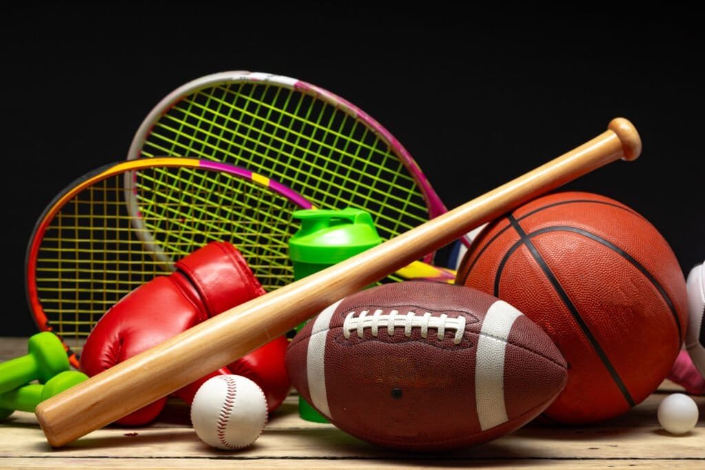 Various sports equipment on black background studio shot